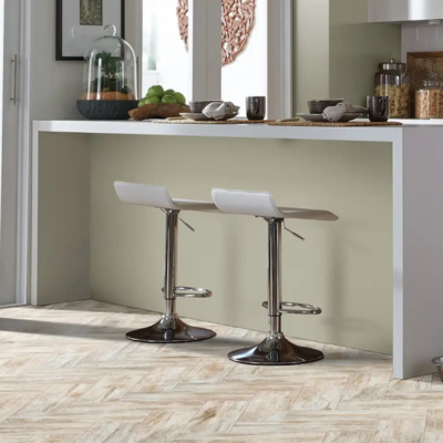 Modern kitchen with herringbone tile flooring, white cabinetry, and a clean, contemporary layout.